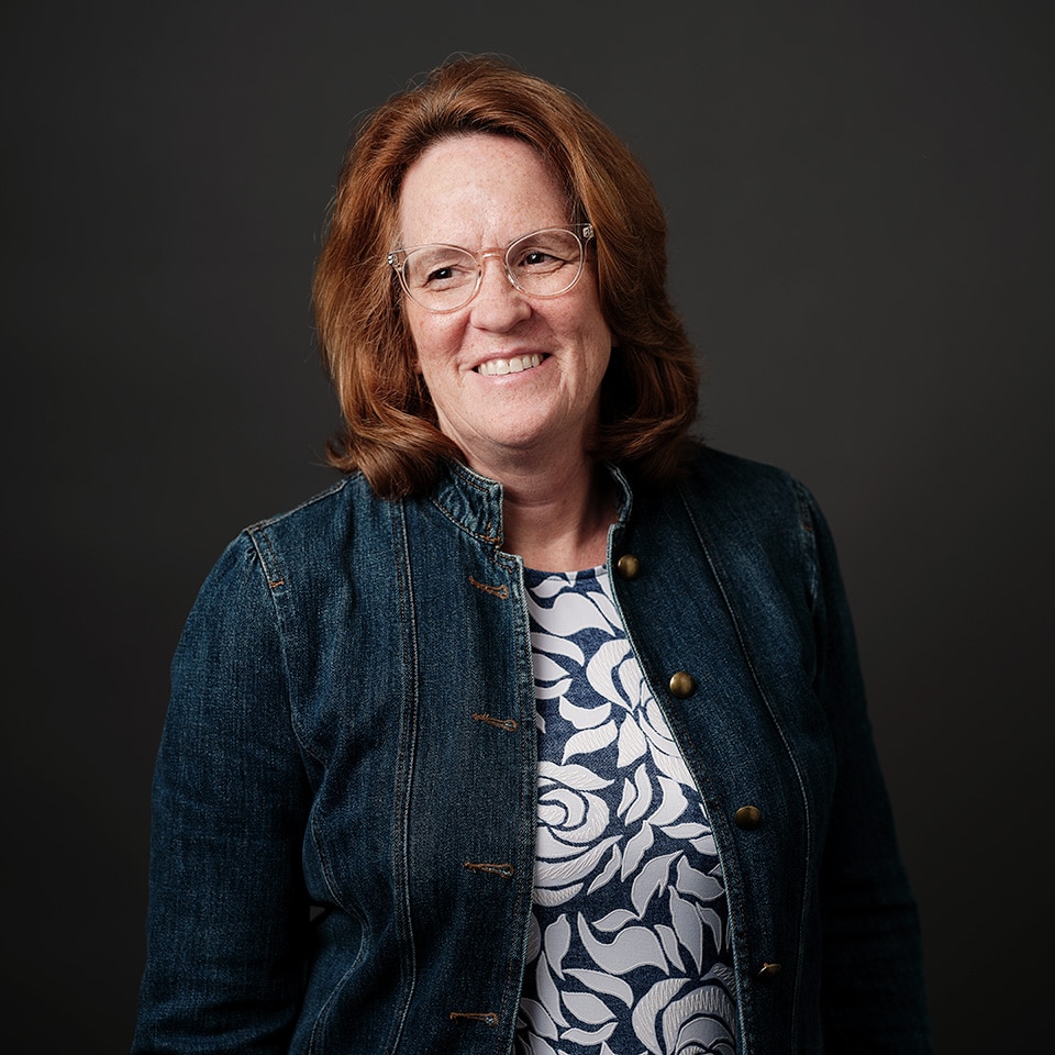 Headshot of Chris Greenlee in a jean jacket smiling off camera.